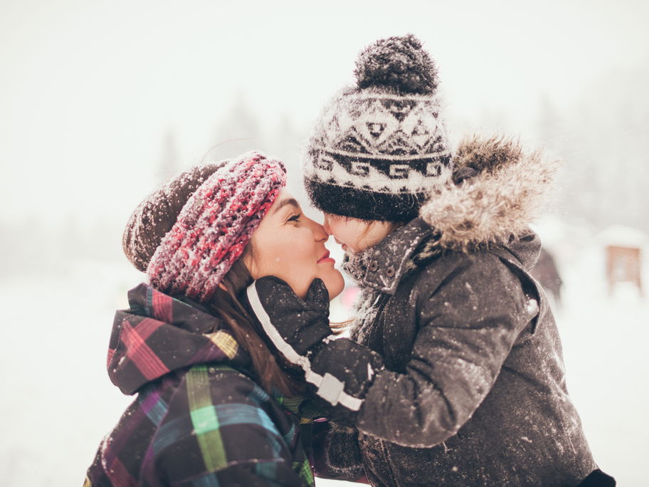 Mama und Kind Nase an Nase im Schnee.