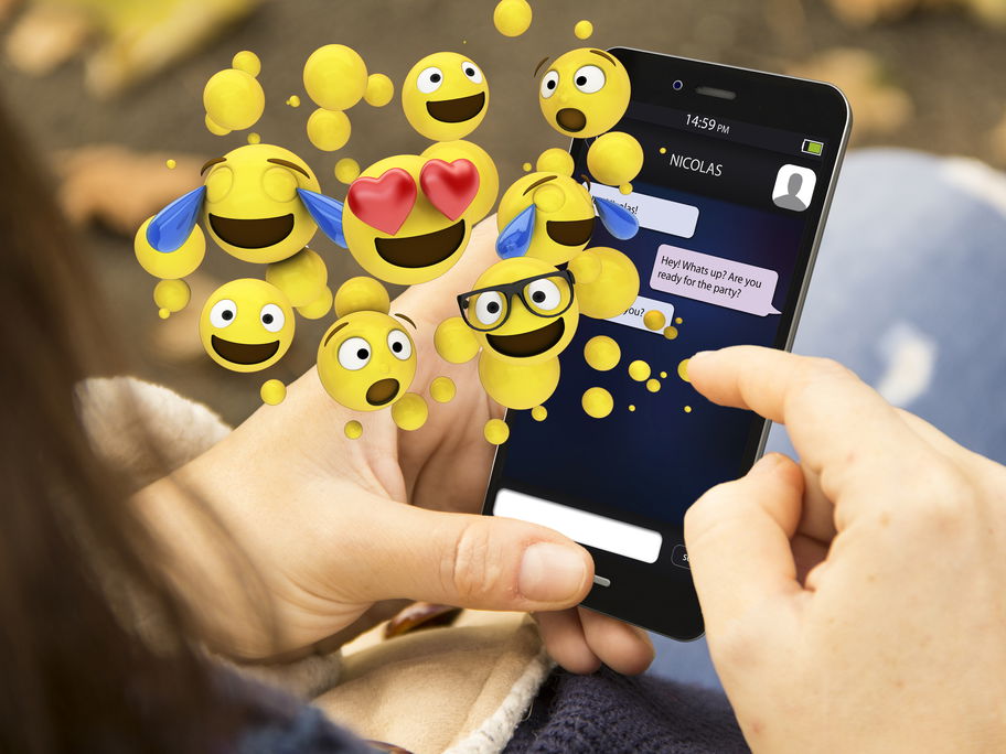 Eine Frau chattet mit Emojis.