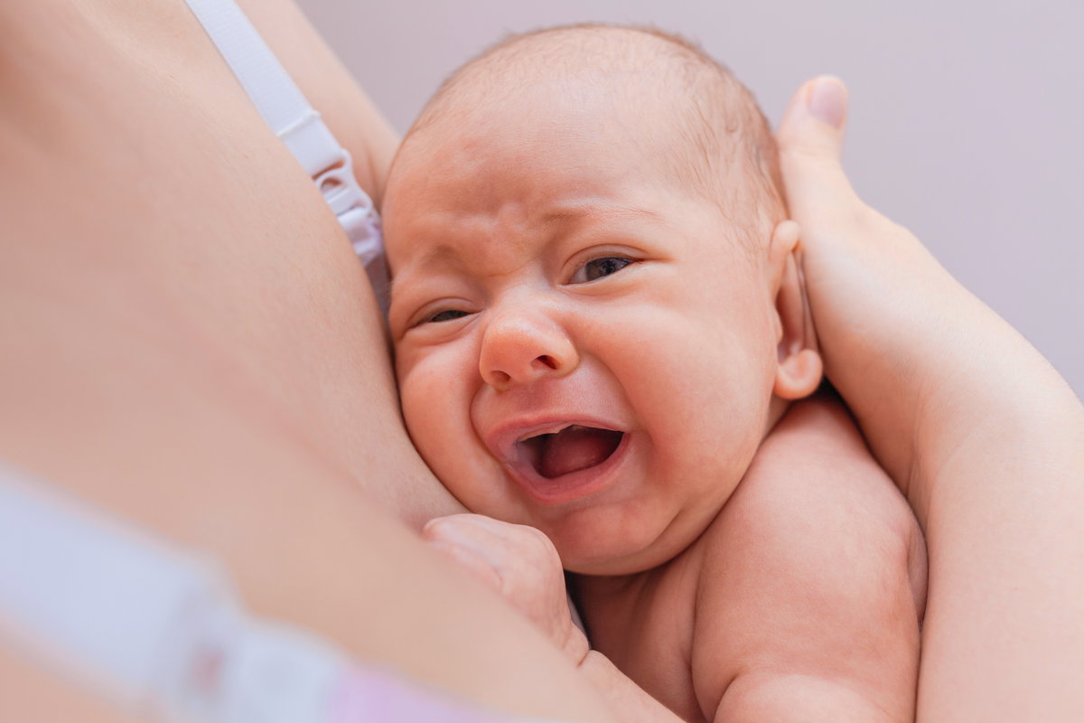 Baby weint an der Brust