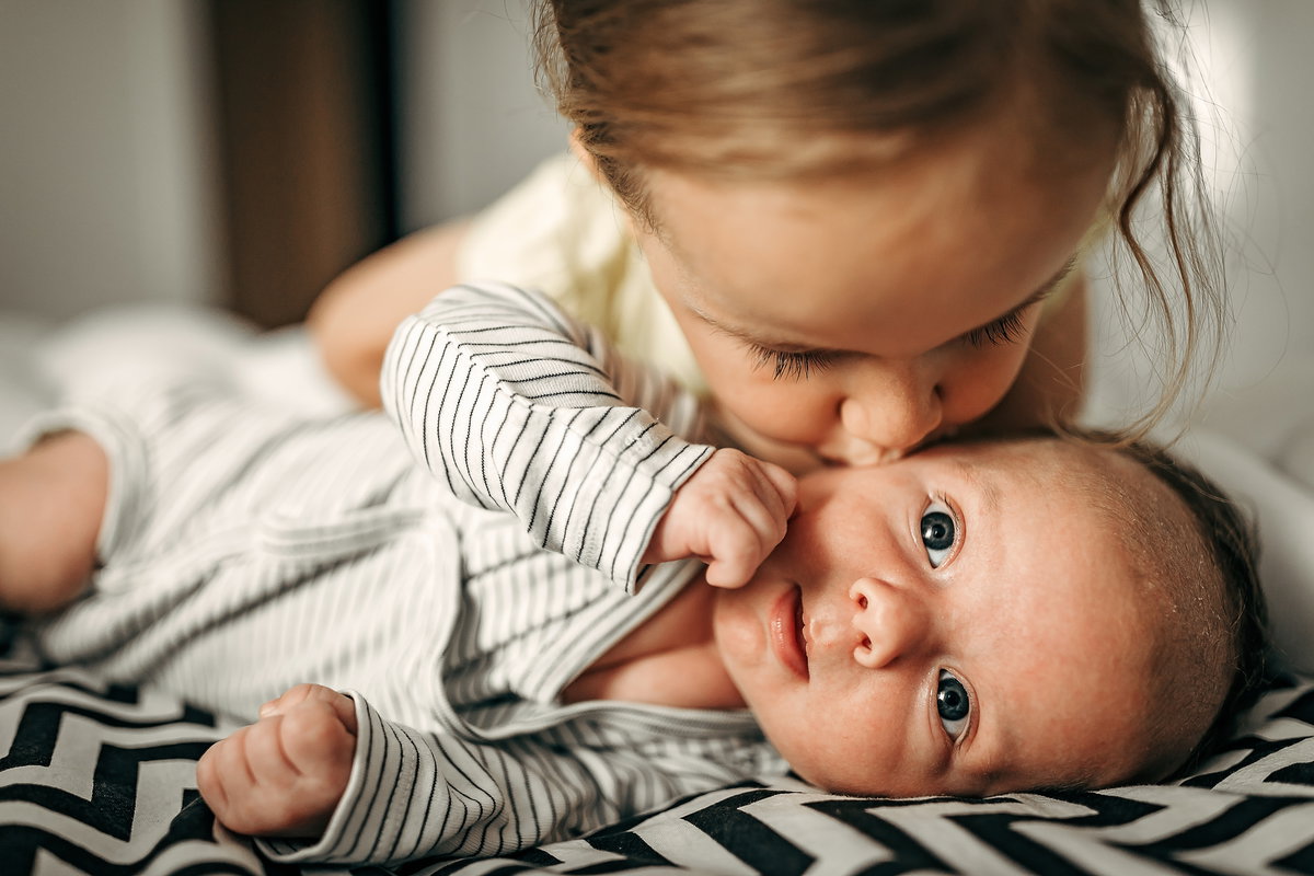 Mädchen küsst Baby