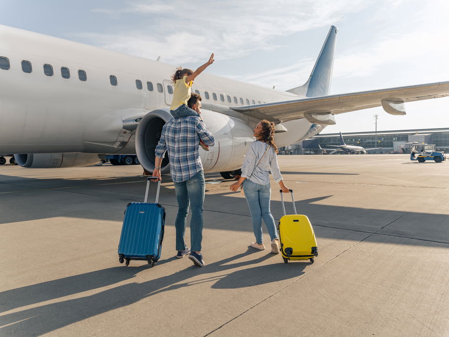 Familie mit schulpflichtigem Kind am Flughafen.
