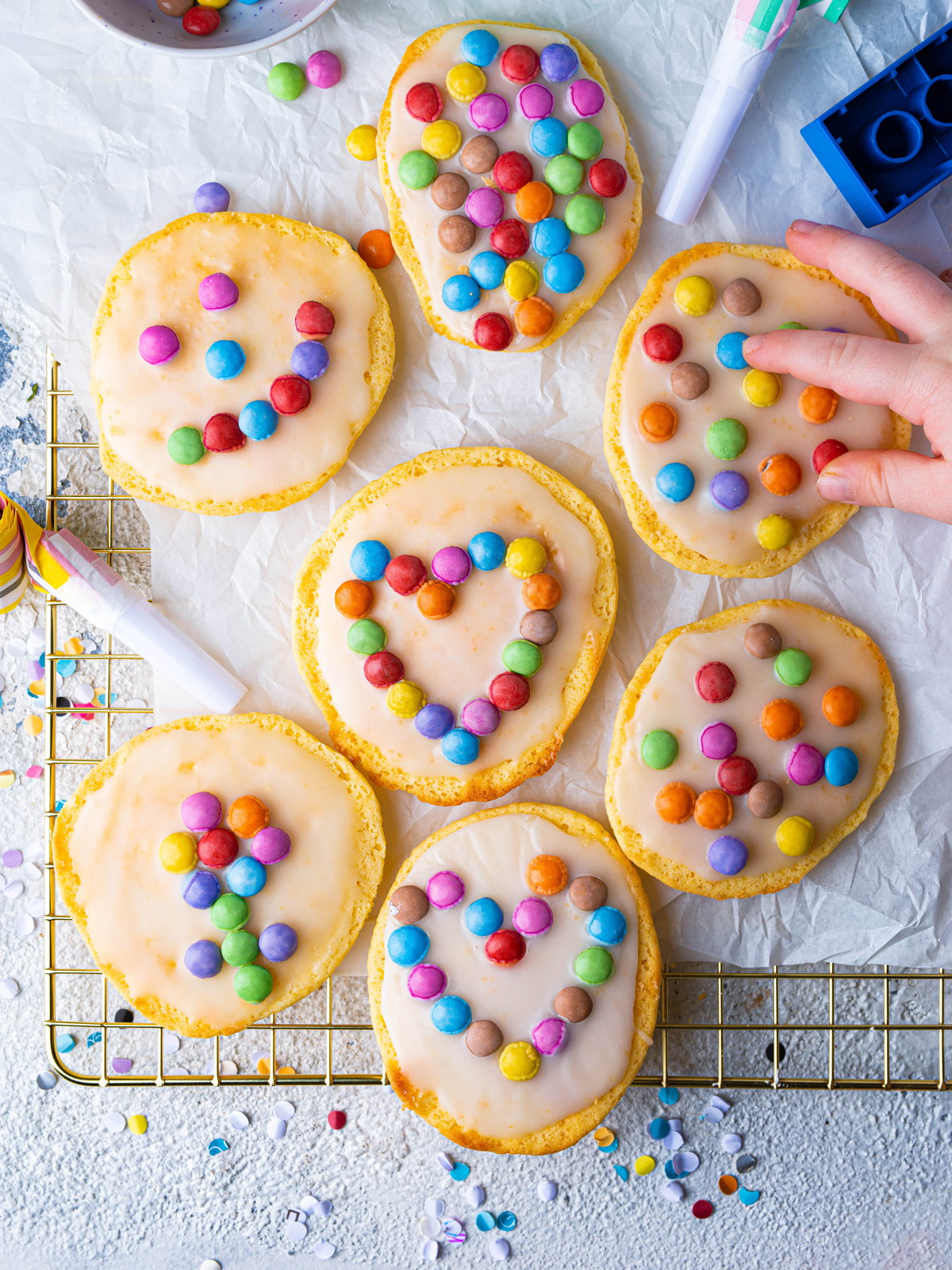 Fantakuchen als Mini-Amerikaner liegen mit Smarties verziert auf dem Backblech.