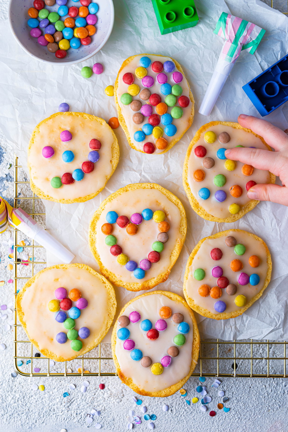 Fantakuchen als Mini-Amerikaner liegen mit Smarties verziert auf dem Backblech.