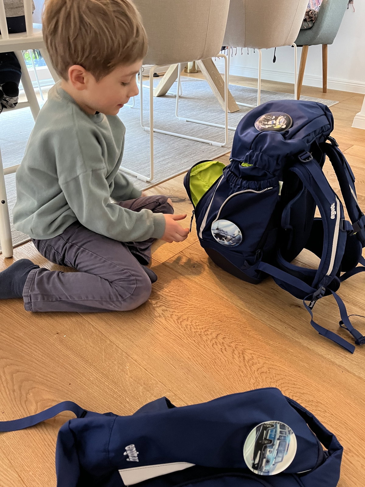 Kind guckt sich Schulranzen an