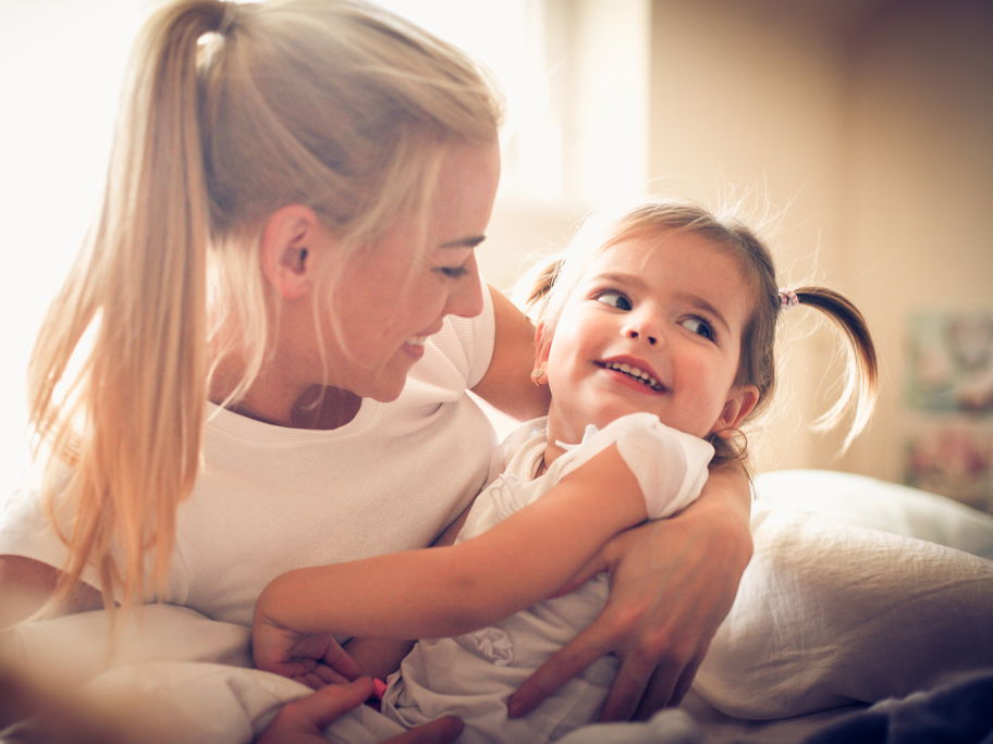 Mutter umarmt ihre kleine Tochter