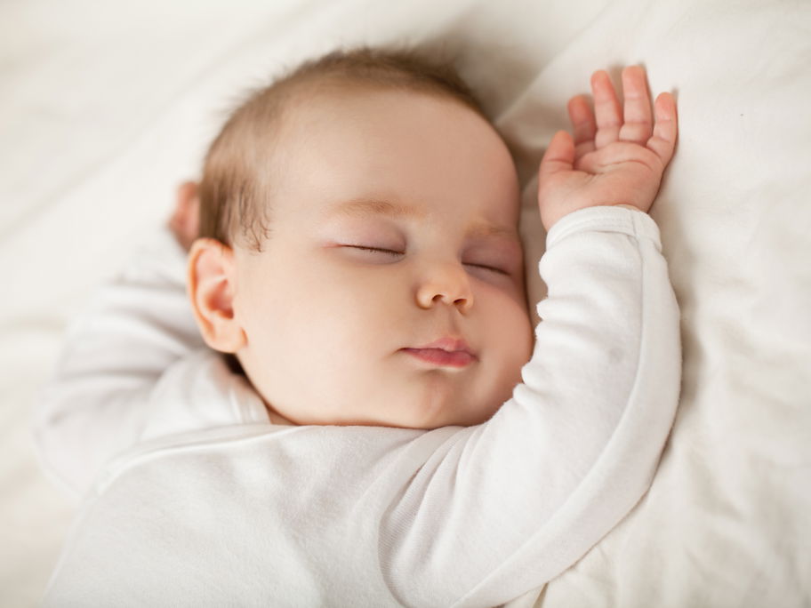 Ein Baby schläft in seinem Bett.