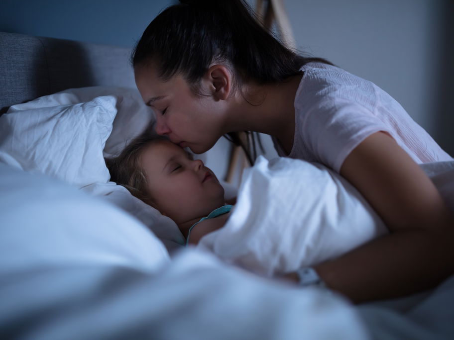Mutter tröstet ihr Kind nach einem Nachtschreck