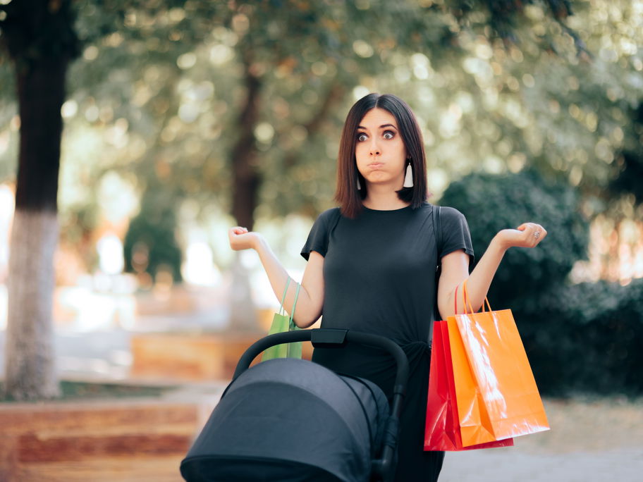 Genervte Frau mit Kinderwagen und Einkaufstüten