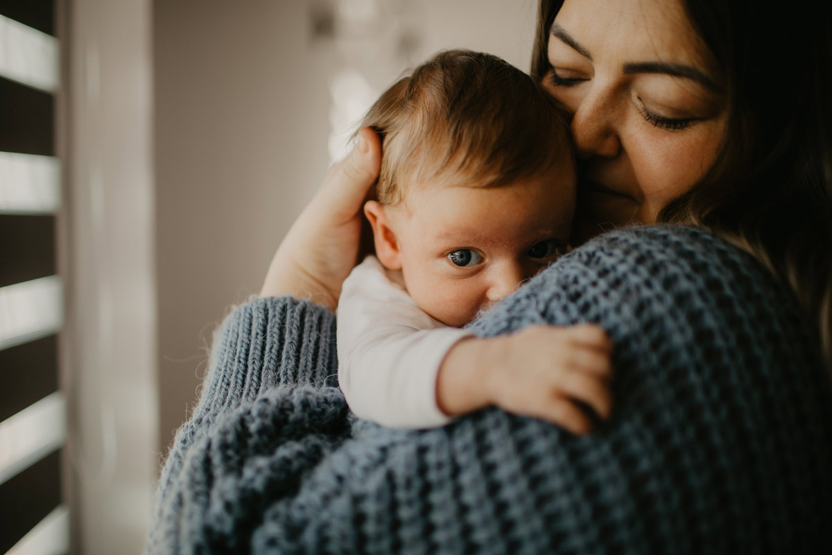 Neugeborener Junge auf dem Arm seiner Mama