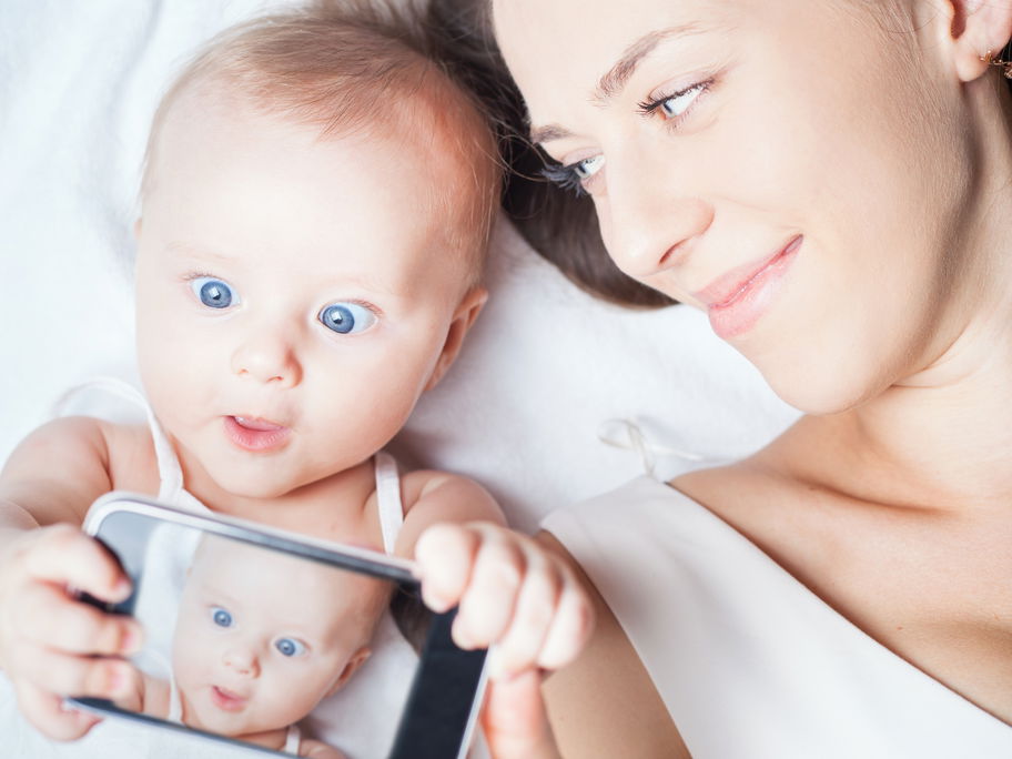 Baby hält Handy in der Hand