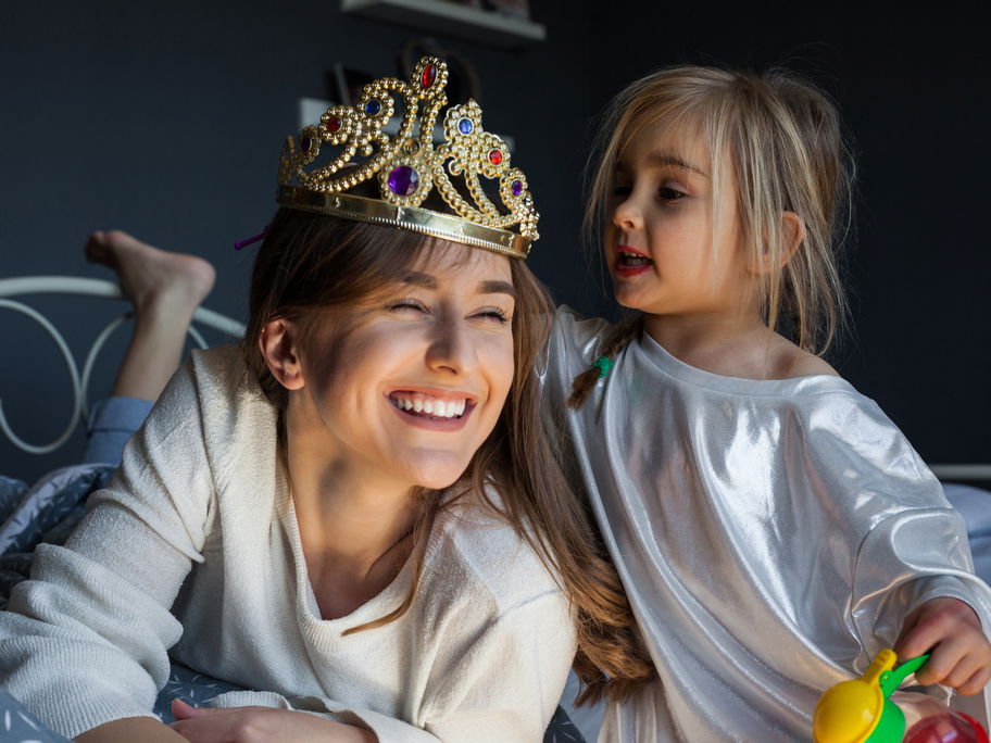 Kleines Mädchen setzt der Mutter eine Krone auf