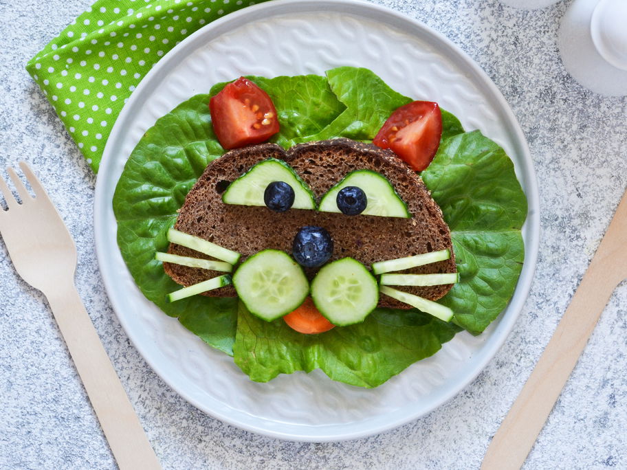 Ein Katzengesicht aus Brot, Obst und Gemüse