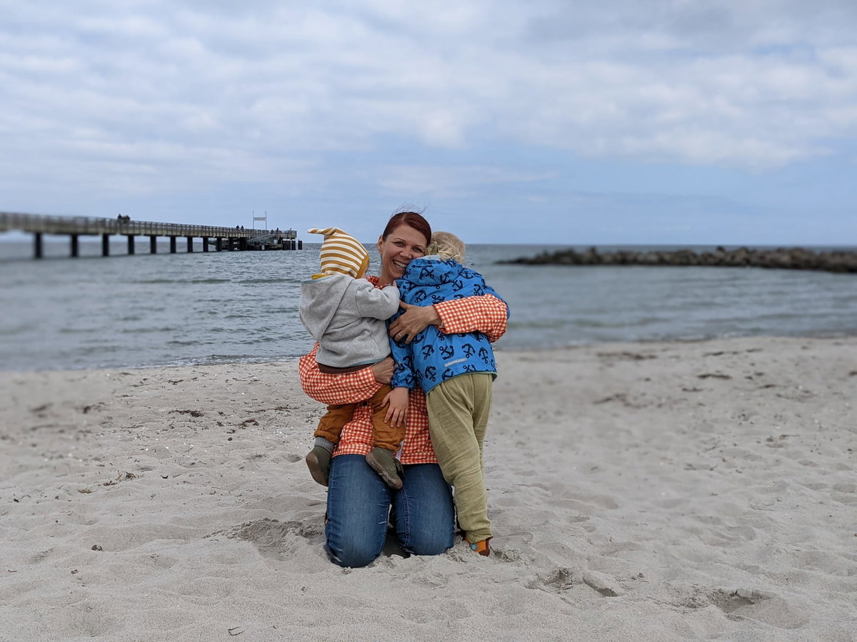 Janin mit ihren beiden Kindern am Strand.