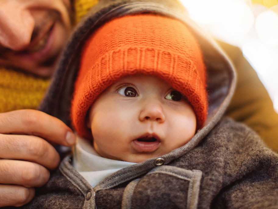 Ein Vater hält sein Baby im Arm.