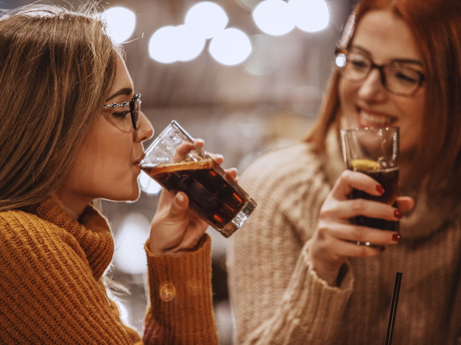 Zwei Frauen trinken Coca Cola.