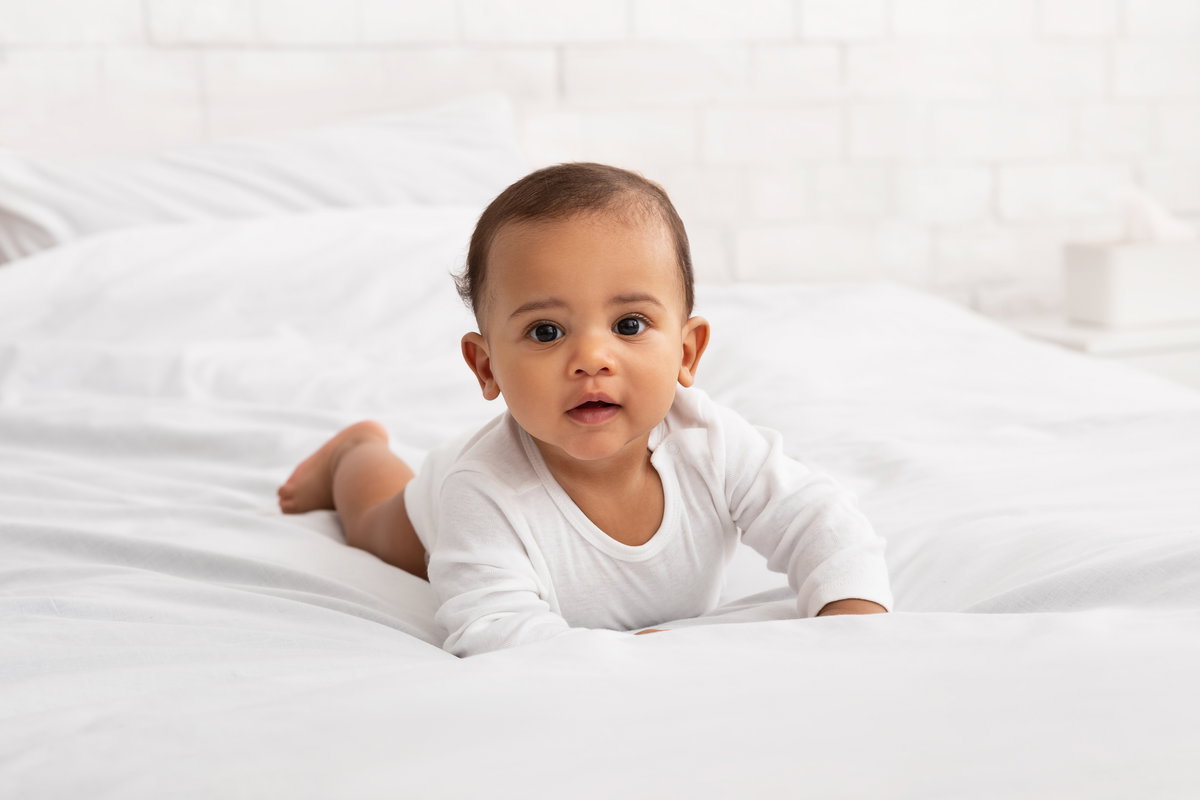 Ein Baby krabbelt auf dem Bett.