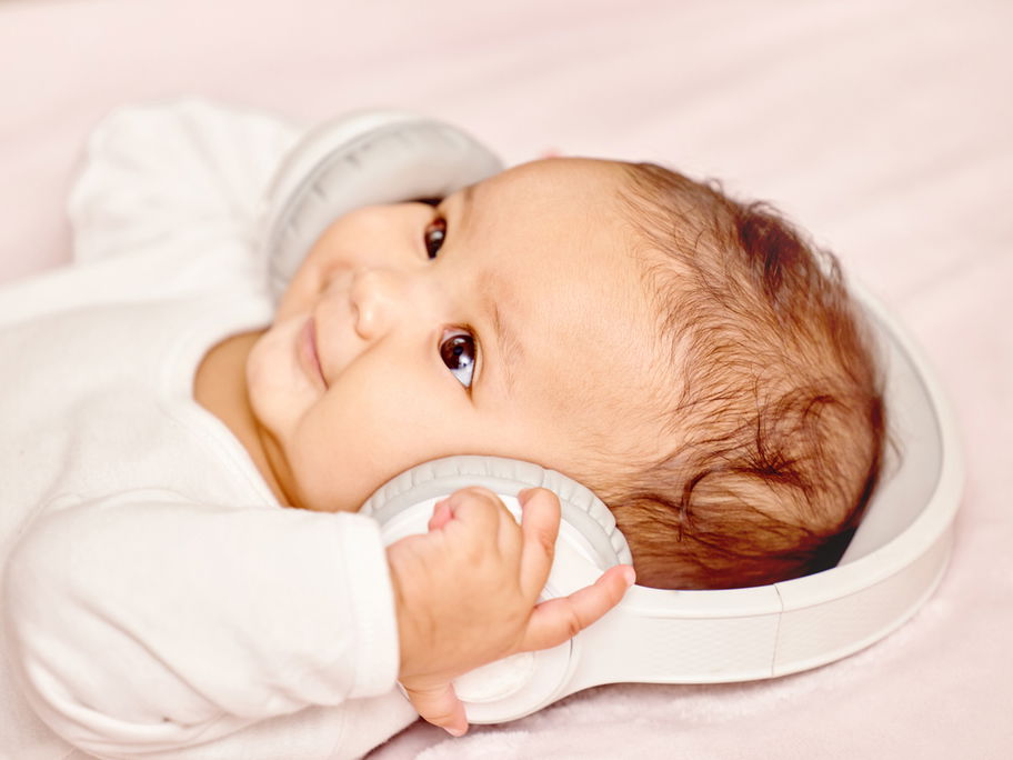 Ein Baby hat Kopfhörer auf den Ohren.