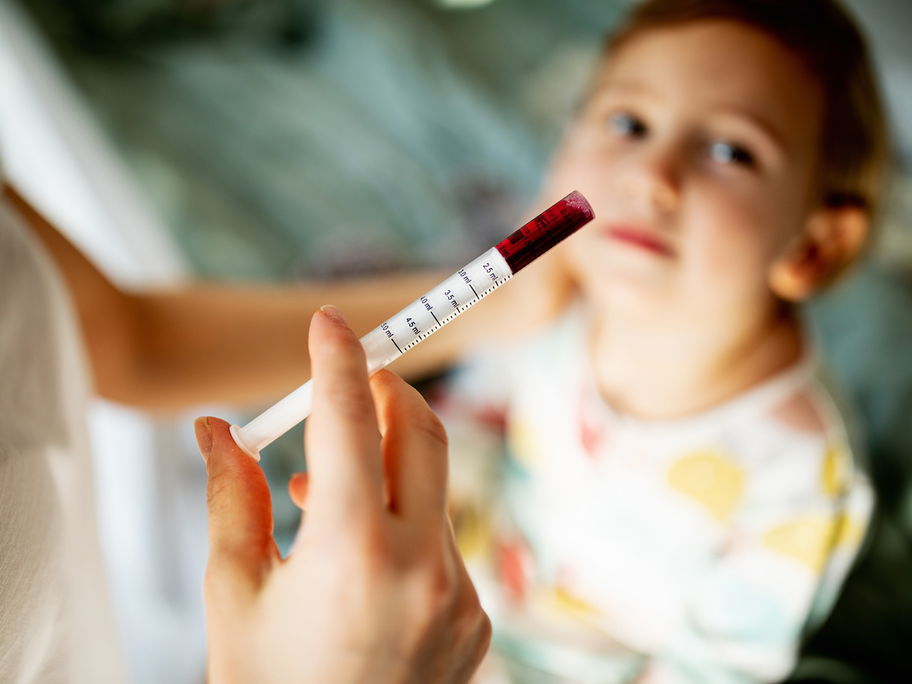 Mutter gibt ihrem Sohn Fiebersaft mit einer Pipette
