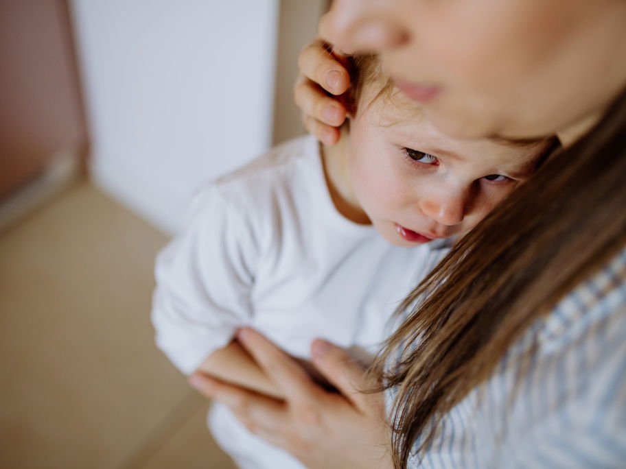Junge weint beim Abschied von seiner Mutter.