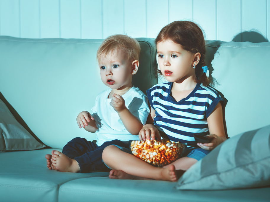 Zwei Kinder sitzen auf dem Sofa