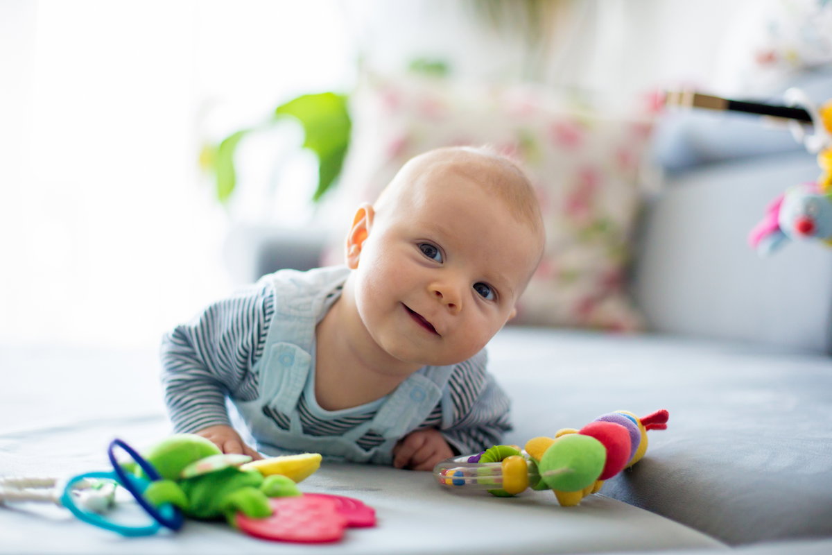 Ein Baby liegt auf dem Sofa und spielt.
