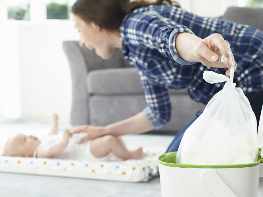 Mama wirft Windel in geruchsdichten Windeleimer