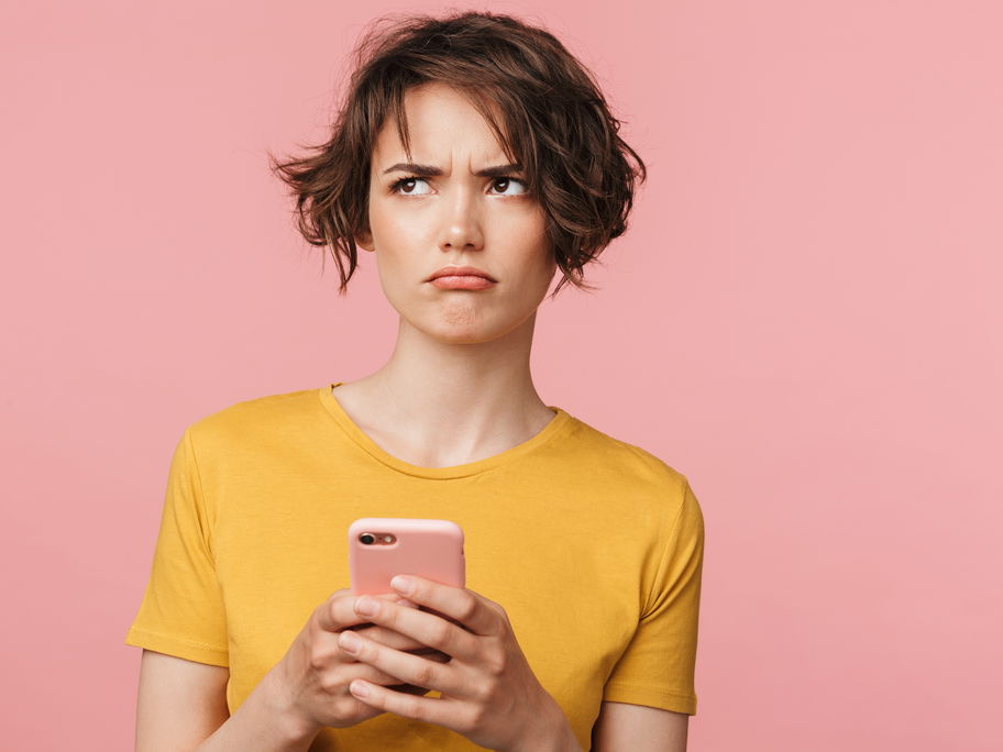 Mutter schaut genervt auf ihr Handy