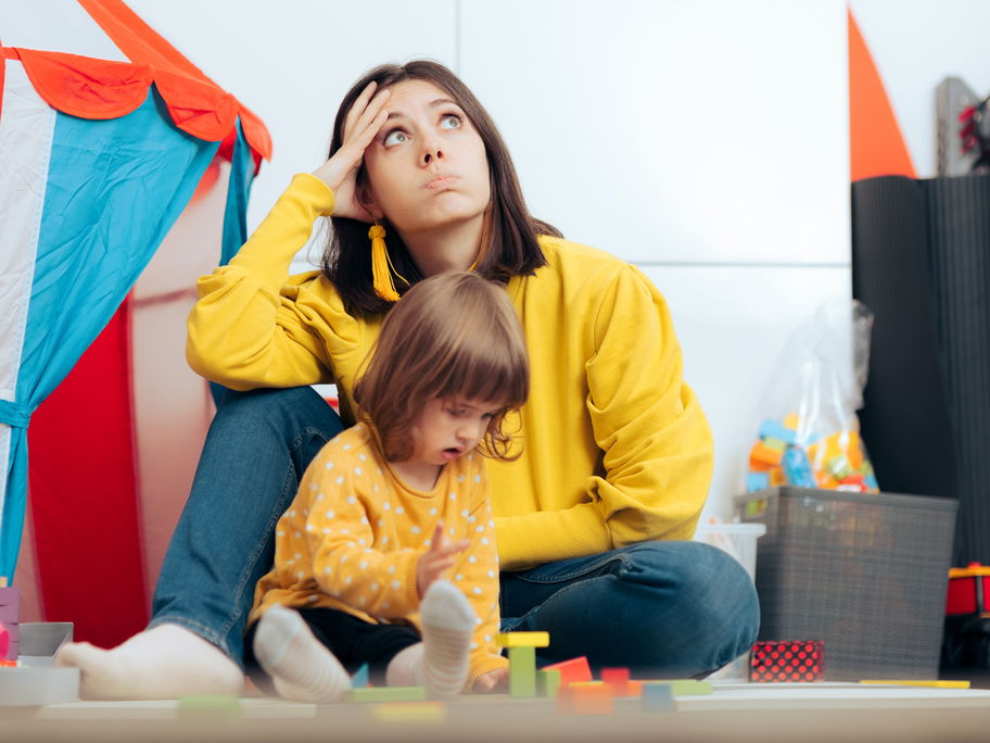 Genervte Mutter mit spielender Tochter.