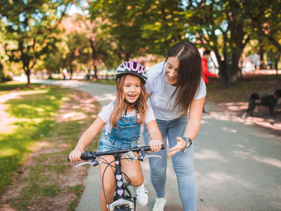Mama bringt Tochter Fahrradfahren bei