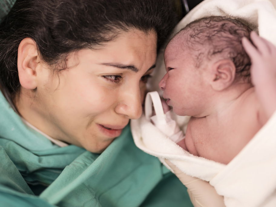 Eine Frau direkt nach der Geburt mit ihrem Baby