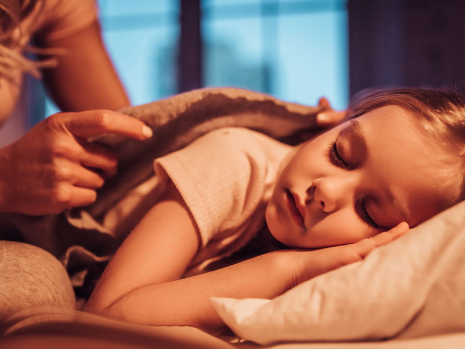 Mutter bringt ihre Tochter ins Bett