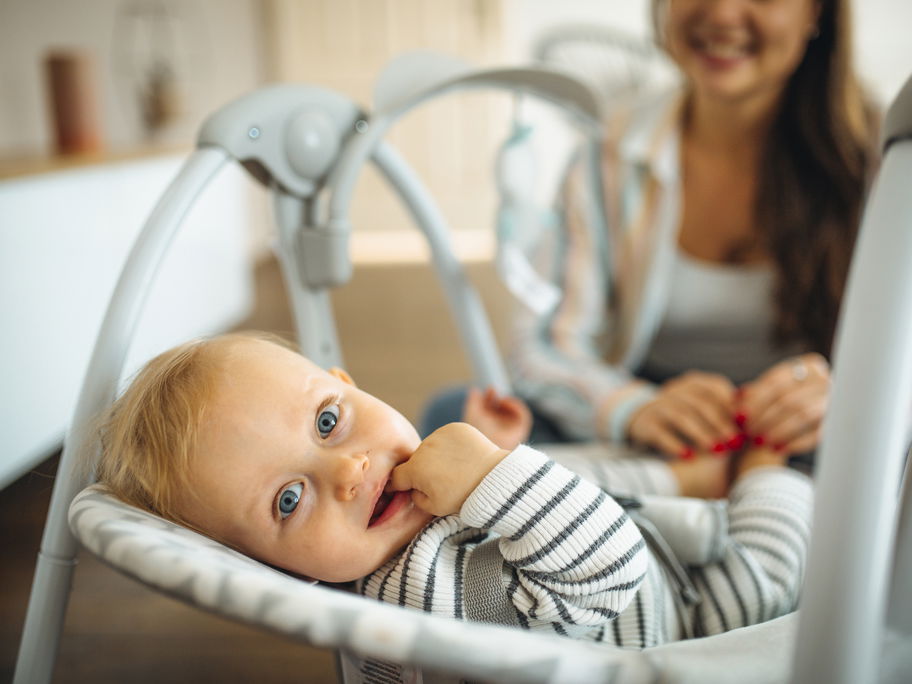 Baby liegt in Babywippe