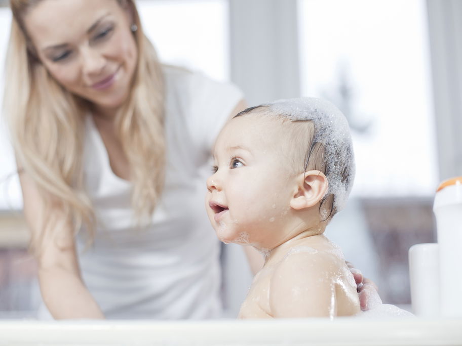 Baby sitzt in faltbarer Babywanne
