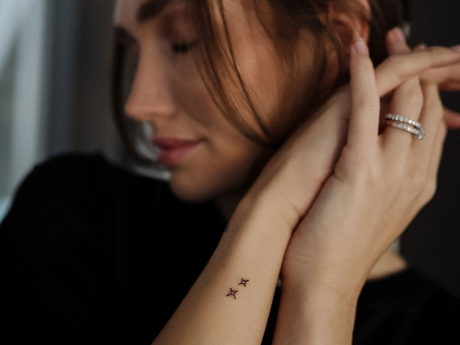 Anna Adamyan zeigt ihre Stern-Tattoos.