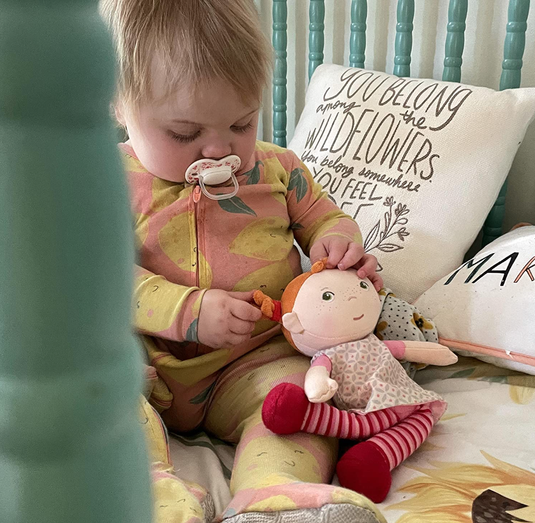 Baby spielt mit Kuschelpuppe