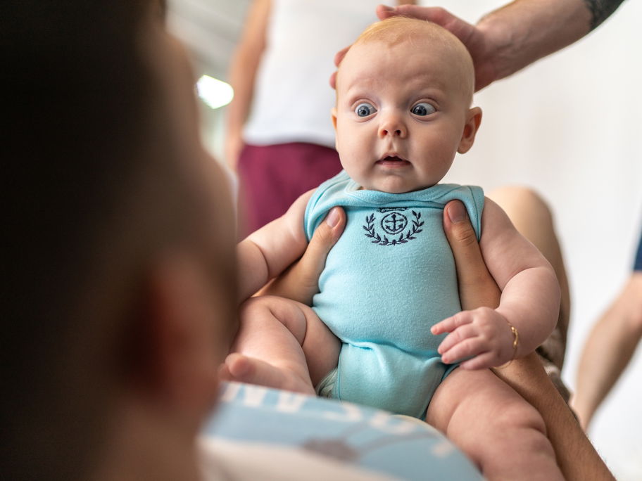 Kleines Baby schaut seinen Papa erschrocken an