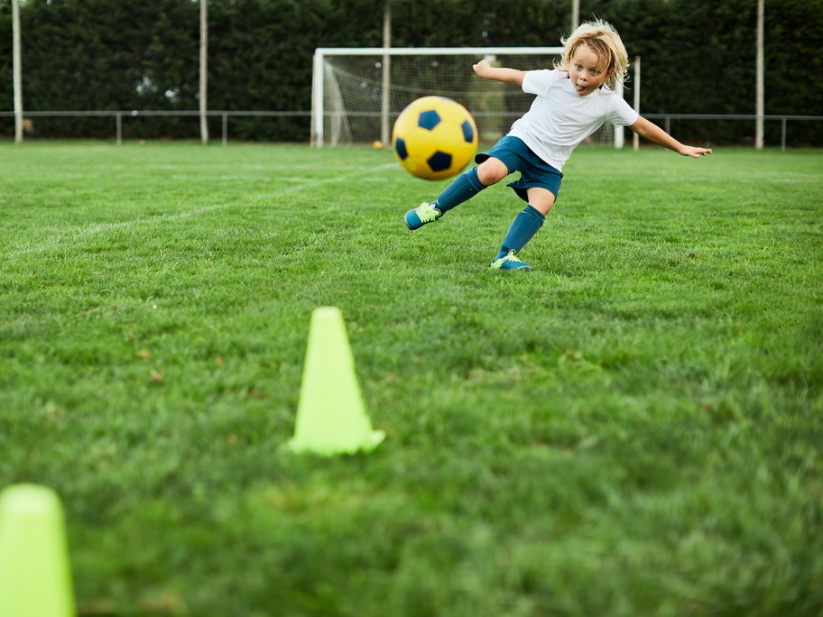 Eine Junge schießt einen Fußball