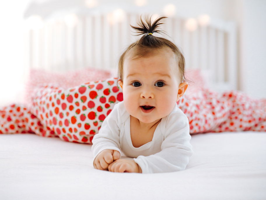 Babymädchen liegt auf dem Bett