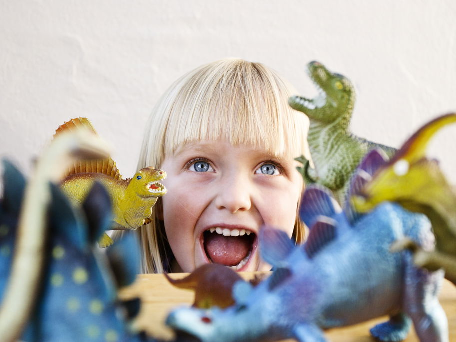 Kleines Mädchen mit Spielzeug Dinos