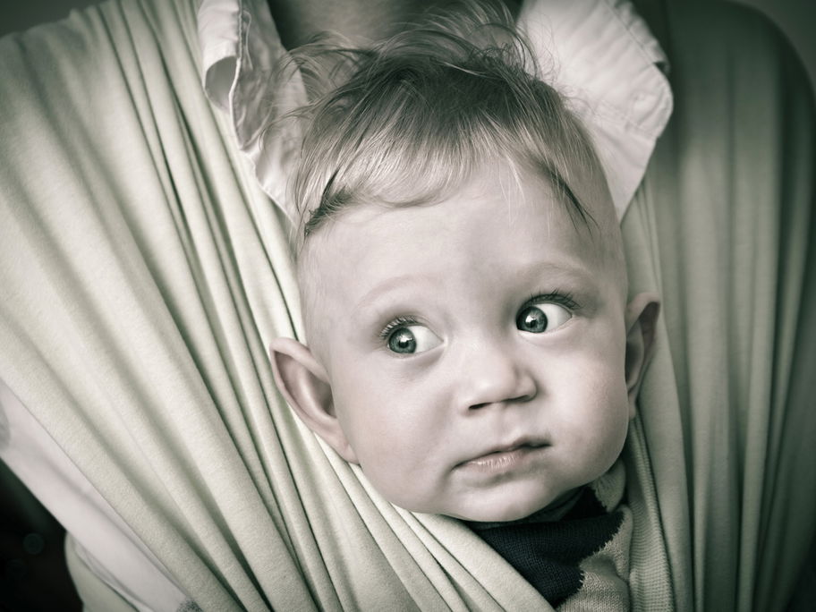 Herr der Ringe: Kleiner Elben-Junge guckt lustig aus der Babytrage heraus.