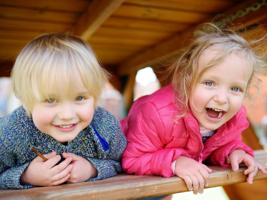 Glückliche Kinder, die Spaß am Spielplatz im Freien haben.