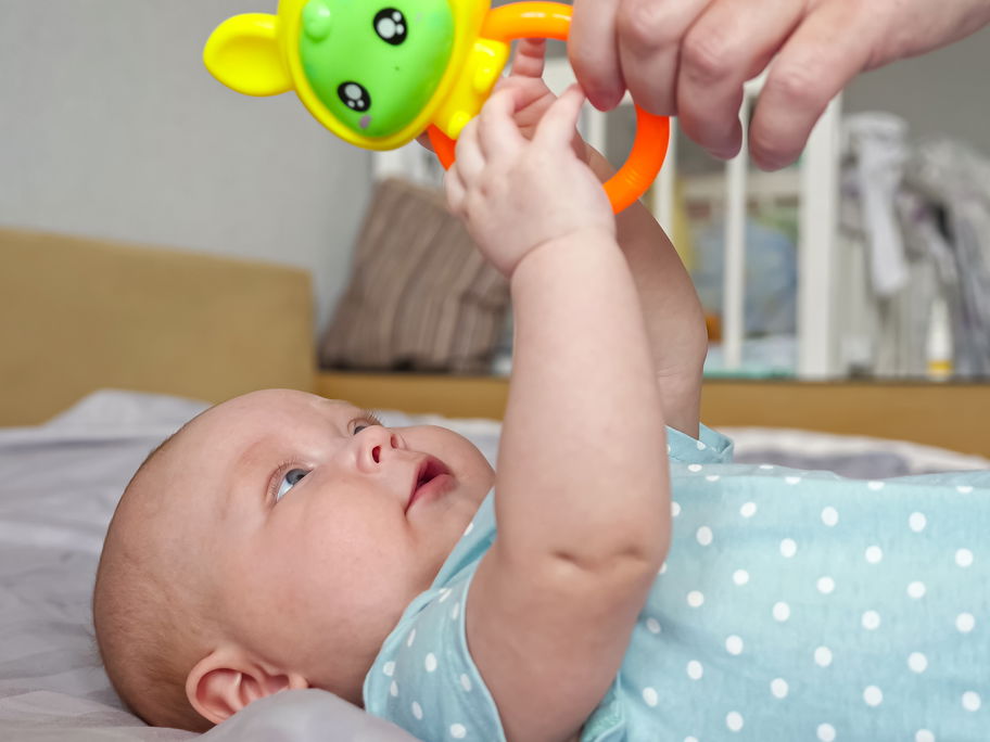 Baby greift nach Beißring
