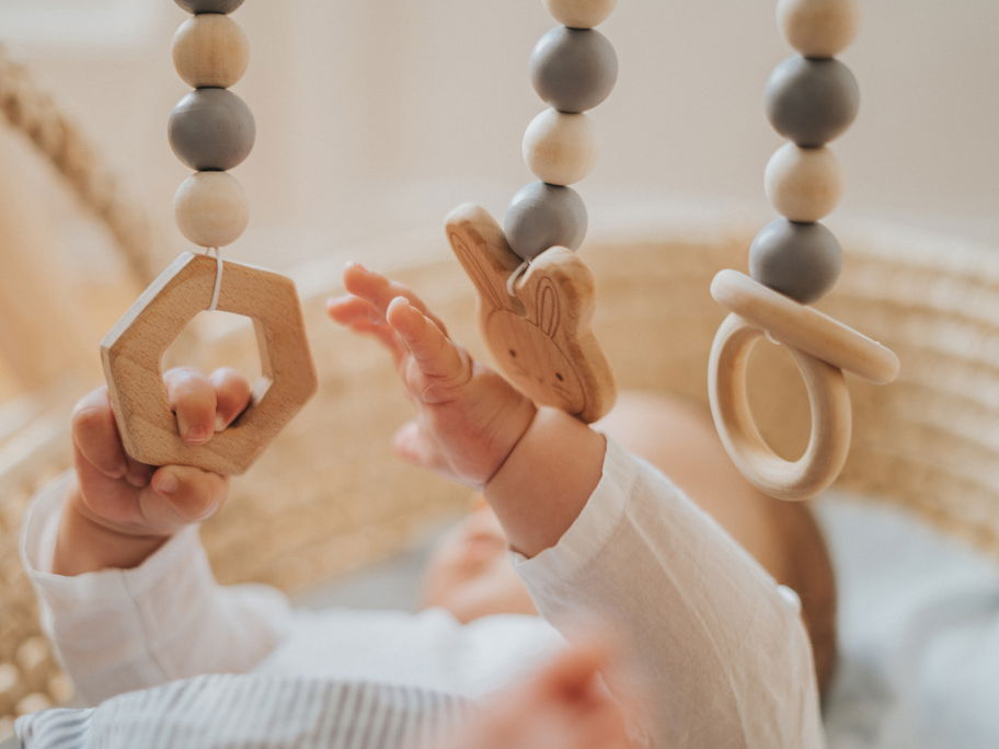Baby spielt mit Holz-Mobile