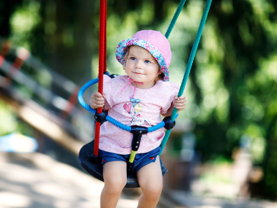 Baby sitzt in Babyschaukel