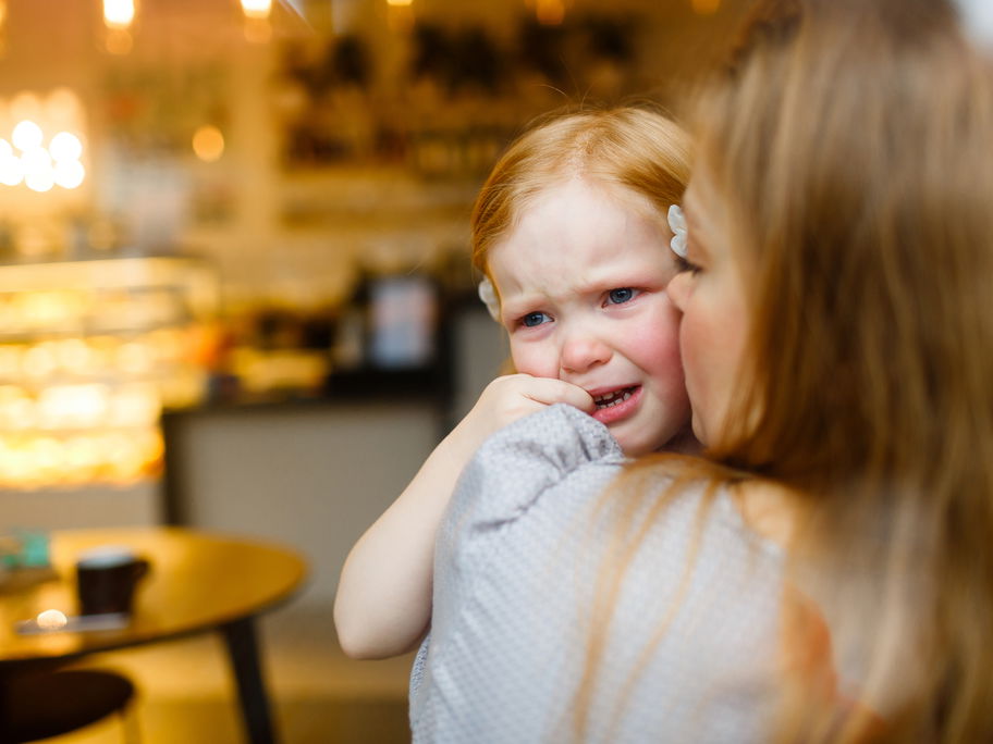 Mama tröstet ihre kleine Tochter