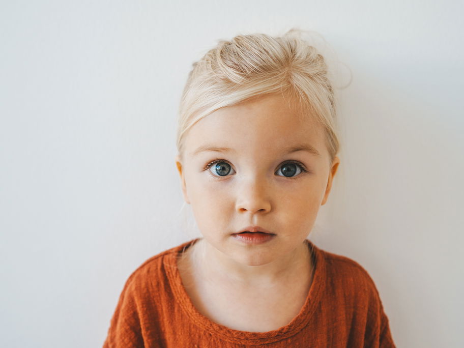 Blondes Mädchen schaut in die Kamera.