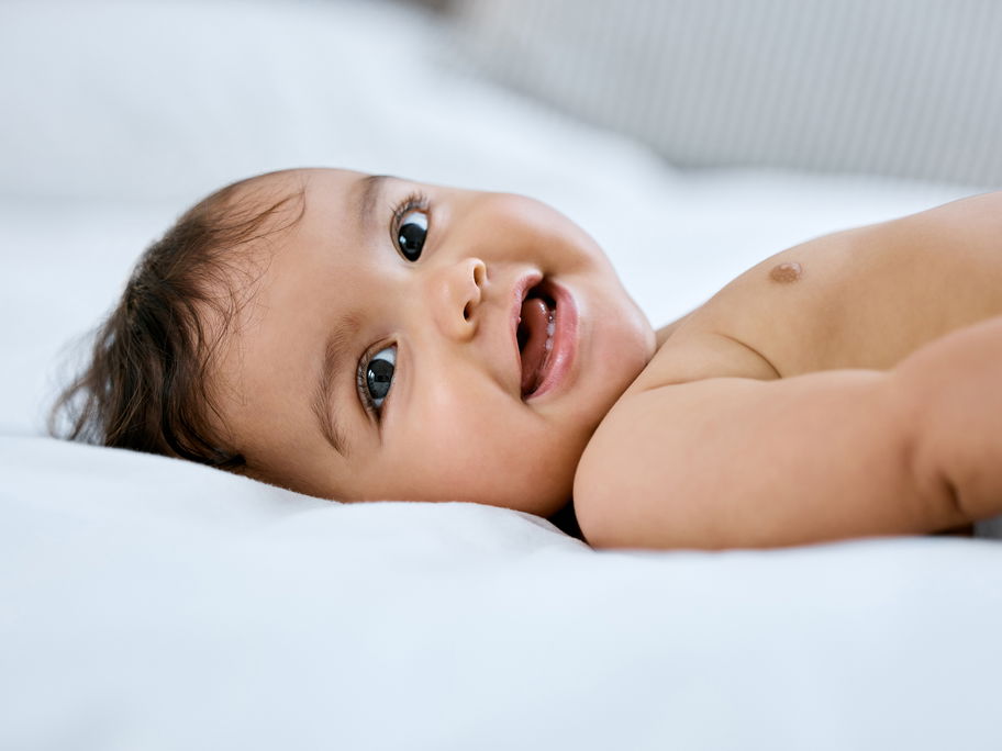 Lachendes Baby im Liegen.