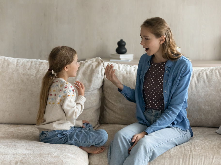 Mutter und Tochter unterhalten sich auf dem Sofa.