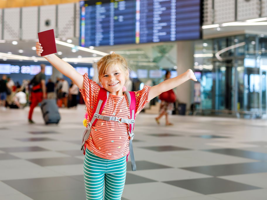 Kleines Mädchen mit Kinderreisepass am Flughafen