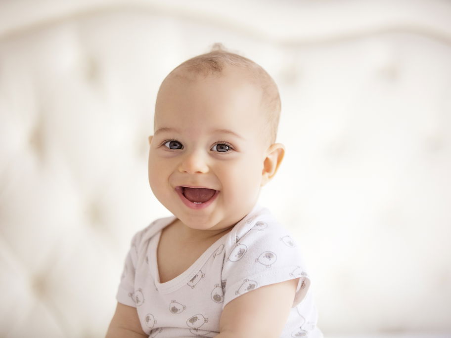 Lachendes Baby im Sitzen.
